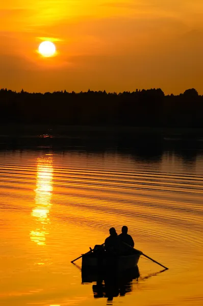 Pescadores em barco ao pôr do sol — Fotografia de Stock