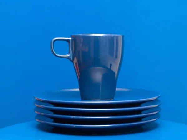 Tazza di caffè blu sulla pila di piatti — Foto Stock