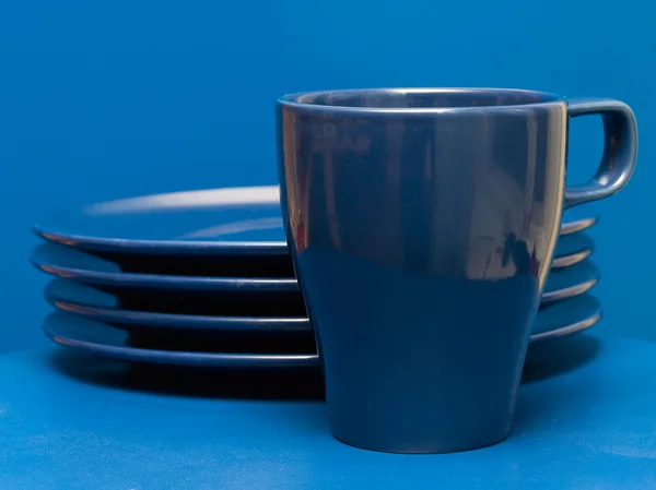 Hrnek modrý kávy a stoh desek — Stock fotografie