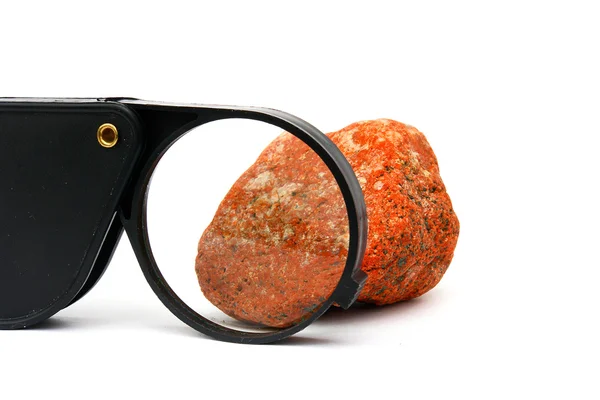 Een zwarte Vergrootglas en steen — Stockfoto