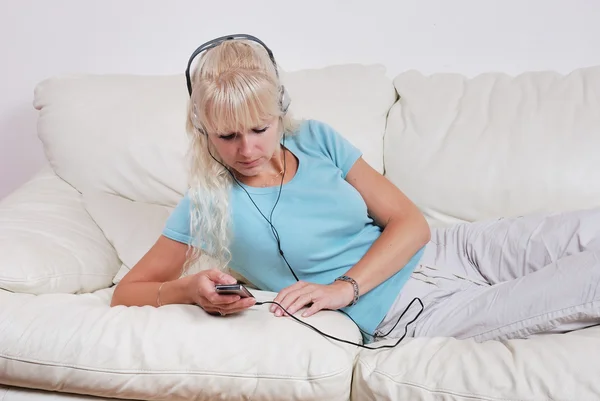 Blonde Frau hört ihren mp3-Player — Stockfoto