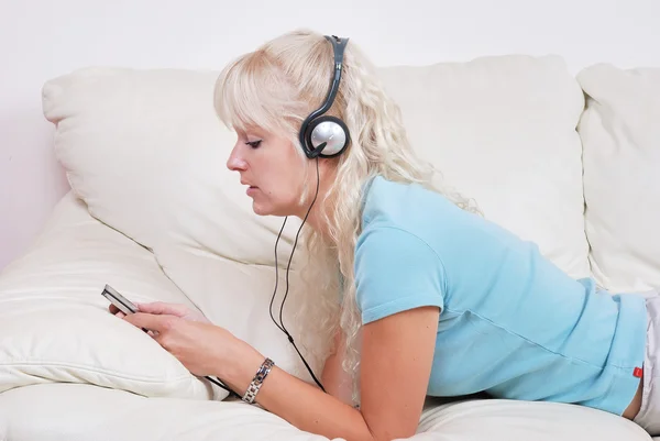 Blond woman listening to her mp3 player — Stock Photo, Image
