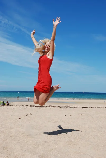 Kobieta skoki na plaży — Zdjęcie stockowe
