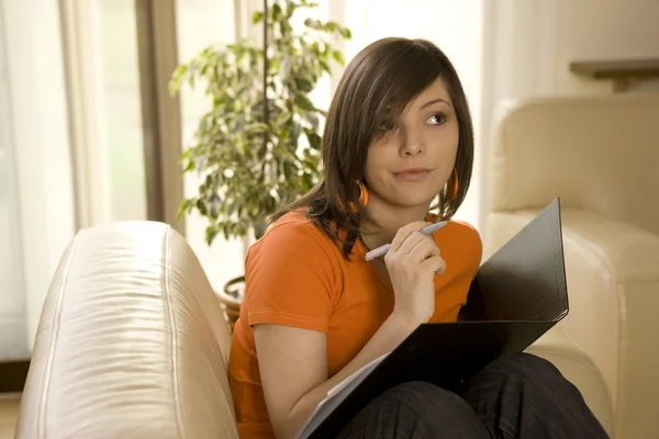 Ung kvinna arbetar eller studerar hemma — Stockfoto