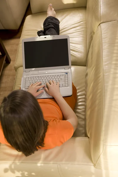 Молода жінка працює вдома зі своїм ноутбуком — стокове фото