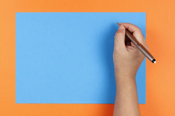 Una mano, penna e carta colorata — Foto Stock