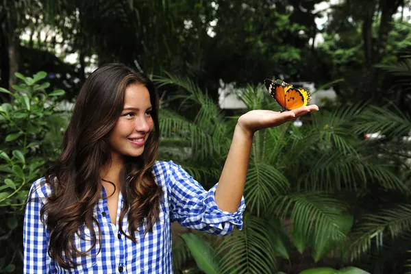 Motýl sedí na ruce mladé ženy i — Stock fotografie