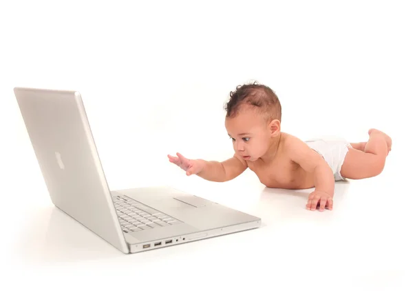 Menino infantil brincando com um computador portátil — Fotografia de Stock