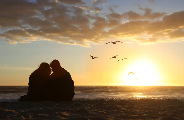 Gelukkige paar kijken naar de zonsondergang verliefd op de — Stockfoto