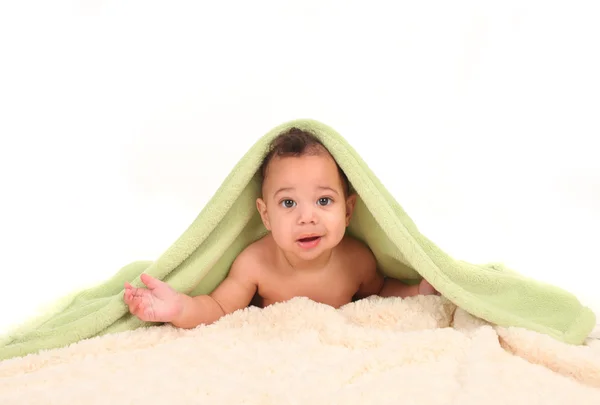 Menino infantil deitado em sua barriga entre cobertores — Fotografia de Stock