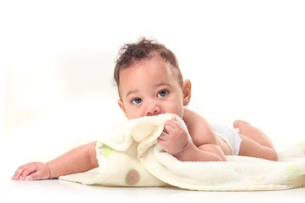 Младенец на животе играет с одеялами — стоковое фото