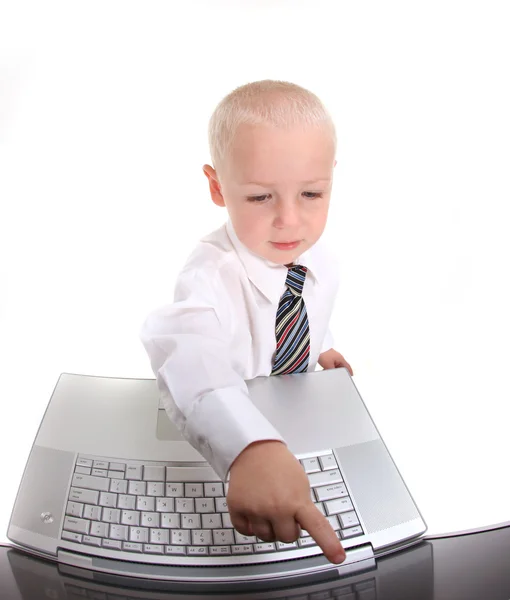 Маленький мальчик в костюме, работающий на ноутбуке — стоковое фото