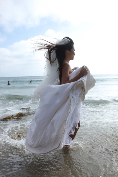 stock image Woman Running in the Ocean in her White Wedding Dress