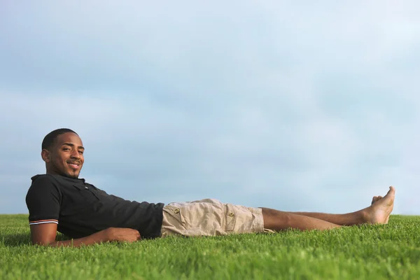 Afrika kökenli Amerikalı adam açık havada yeşil çim dinlenme — Stok fotoğraf