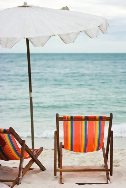 Dvě židle a deštník na pláži — Stock fotografie