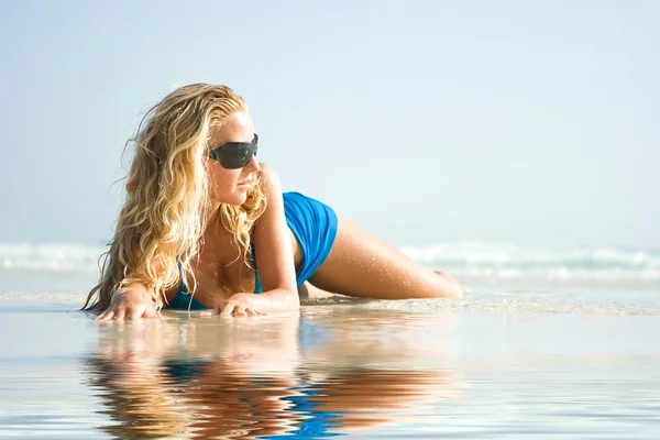 Mädchen am Strand mit Spiegelung im Wasser — Stockfoto
