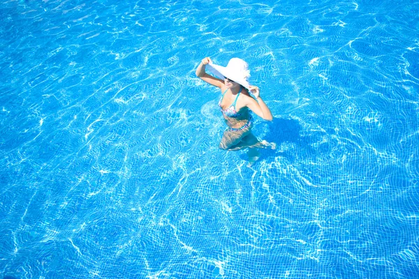 Dziewczyna, biały kapelusz i basen — Zdjęcie stockowe