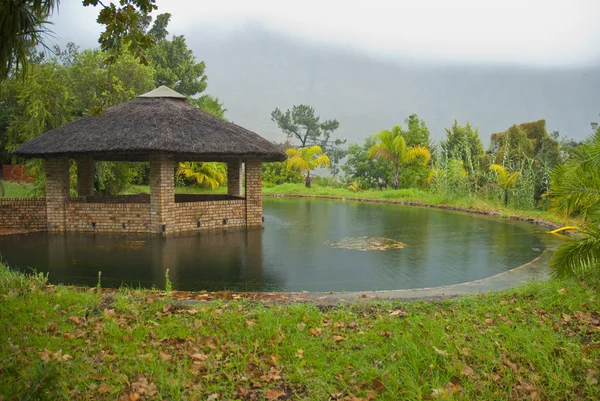 stock image Grass roofed, brick gazebo