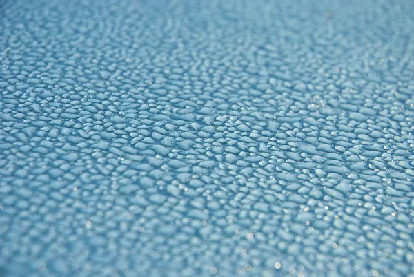 Stock image Dew drops on blue metallic surface