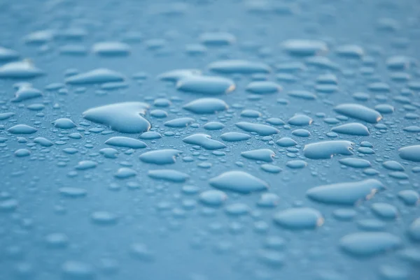 Stock image Dew drops on blue metallic surface