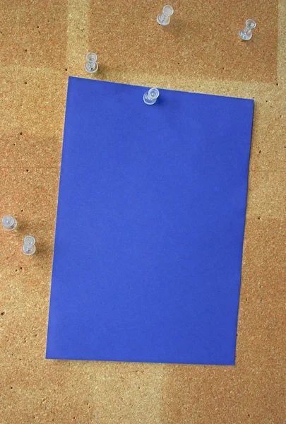 Blue paper sheet pinned to corkboard — Stock Photo, Image