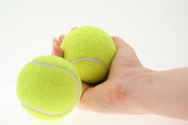 Рука с двумя теннисными мячами — стоковое фото