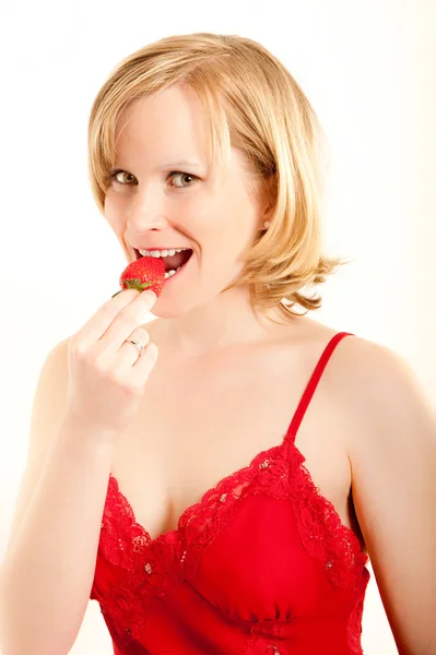 Ung kvinna biter i en färsk jordgubbe — Stockfoto