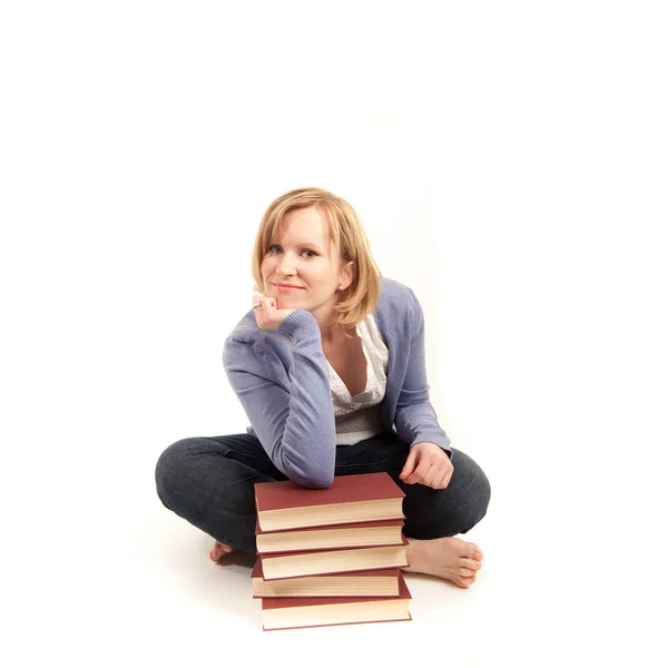 Mladá žena s hromadou knih — Stock fotografie
