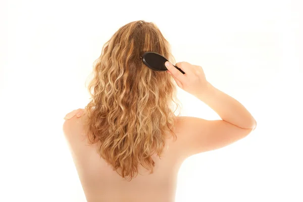 Νεαρή γυναίκα βούρτσισμα τα μαλλιά — Φωτογραφία Αρχείου