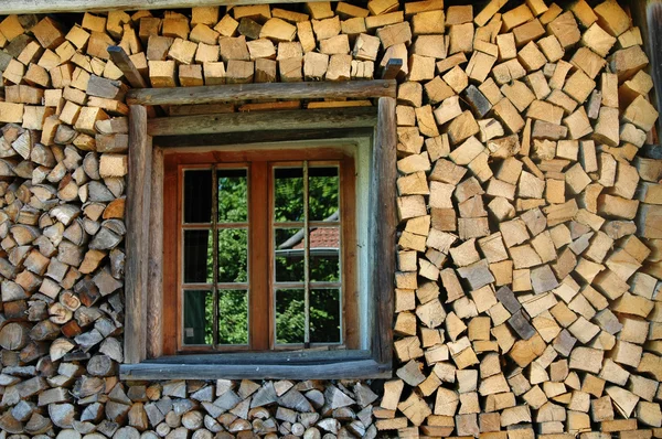 stock image Stack of firewood with window