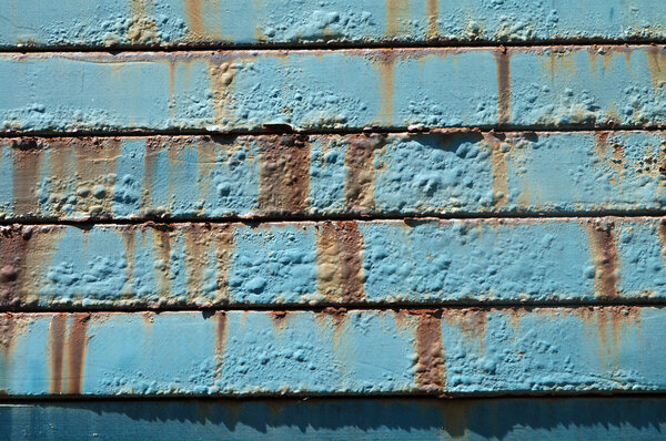 Metal surface with blue paint and rust