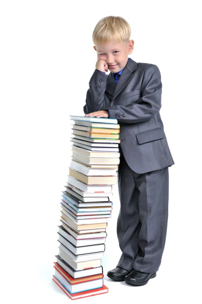 Ung pojke med en hög med böcker — Stockfoto