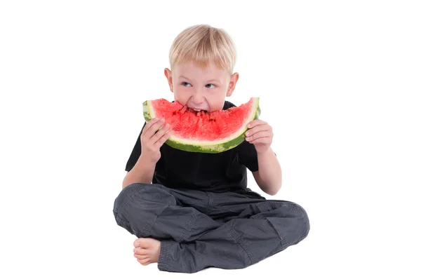 Junge isst eine Wassermelone — Stockfoto