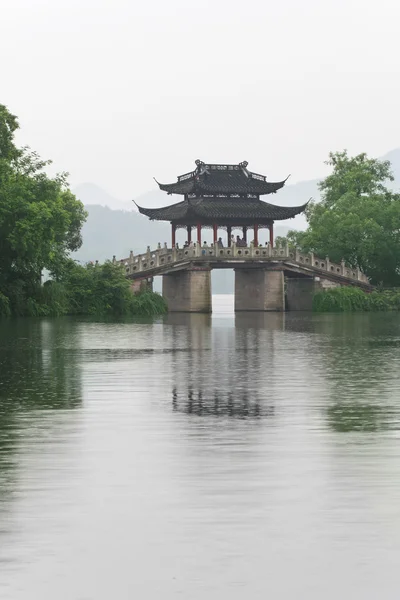 Puente viejo y lluvia del lago occidental chino — Foto de Stock