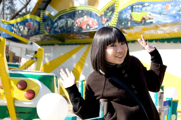 Menina engraçada em um parque de diversões — Fotografia de Stock