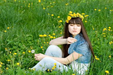 Dandelions arasında oturan kız