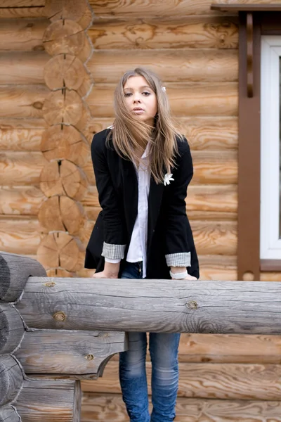 Девушка перед деревянным домом — стоковое фото