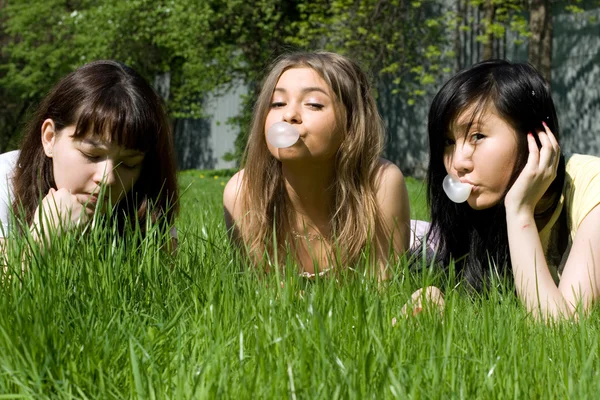 Três meninas deitadas na grama — Fotografia de Stock