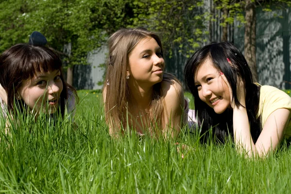 Trzy dziewczyny, leżąc na trawie — Zdjęcie stockowe