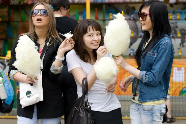 Три девушки едят сладкую нитку — стоковое фото