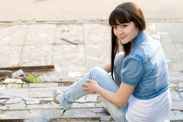 Дівчина сидить на сходах на вулиці — стокове фото