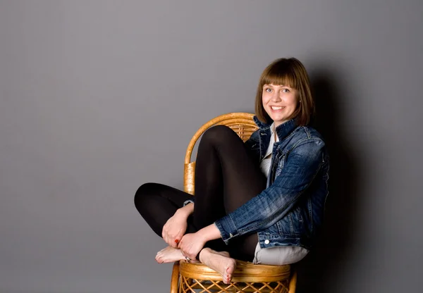 Atrakcyjna dziewczyna siedzi na krześle — Zdjęcie stockowe