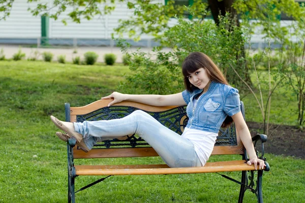 Dívka ležící na lavičce — Stock fotografie