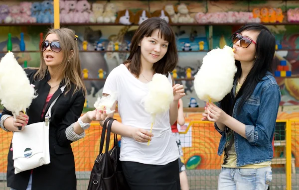 Tres chicas comiendo hilo de caramelo — Foto de Stock