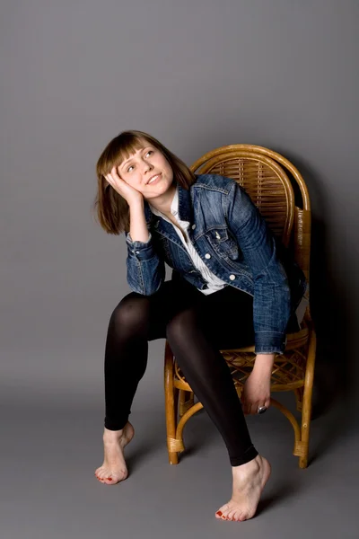 Aantrekkelijk meisje, zittend op een stoel — Stockfoto