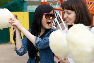 Two girls eating candy floss clipart