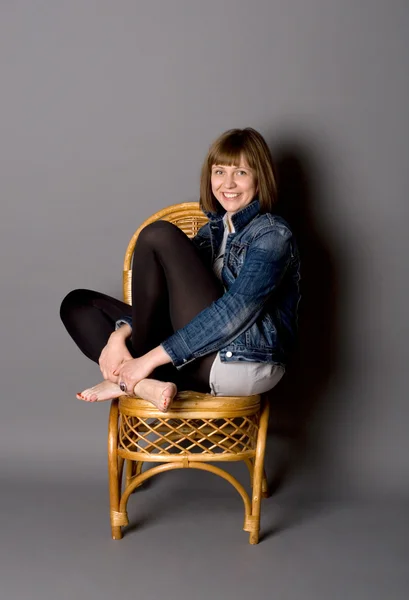 Menina atraente sentada na cadeira — Fotografia de Stock