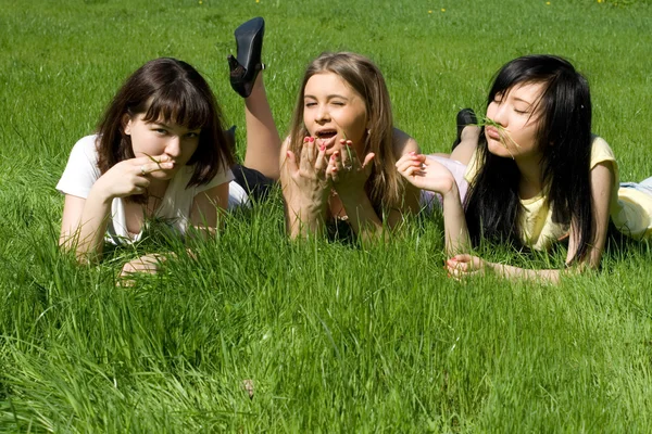 Tři dívky ležet na trávě — Stock fotografie