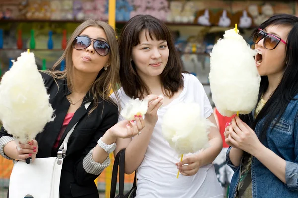 Tres chicas comiendo hilo de caramelo — Foto de Stock