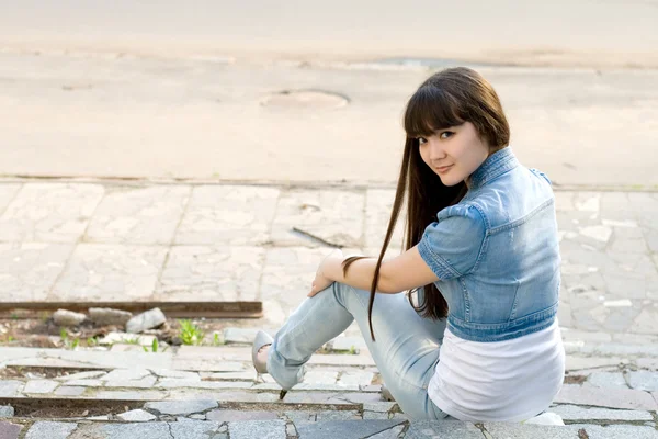 Menina sentada nas escadas ao ar livre — Fotografia de Stock